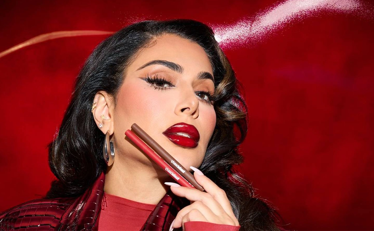 huda beauty lip contour stain Huda Kattan is promoting her new lip contour with red background and new trend makeup on her face