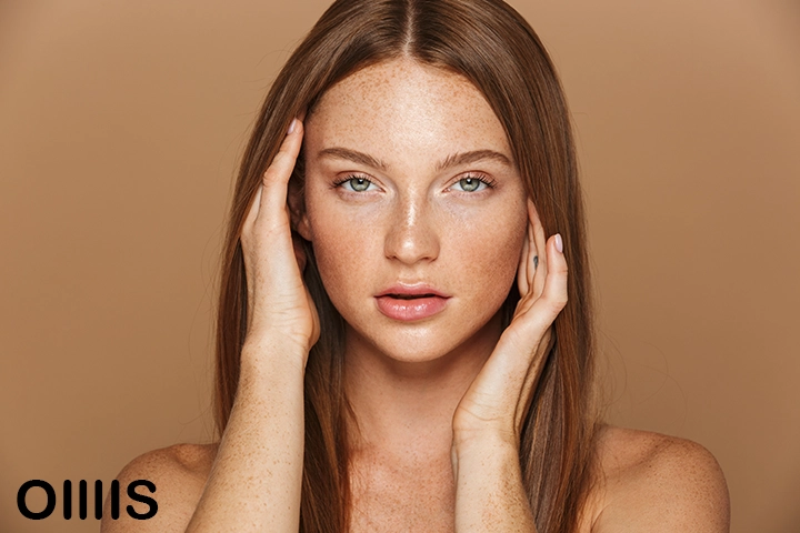 a pretty face young lady looking at the camera from close up with nude brown background